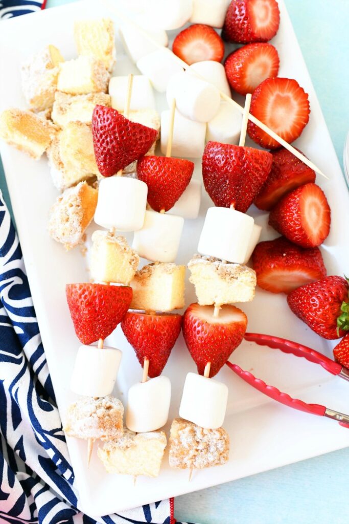 cake cubes, marshmallows, strawberries kabobs on white plate