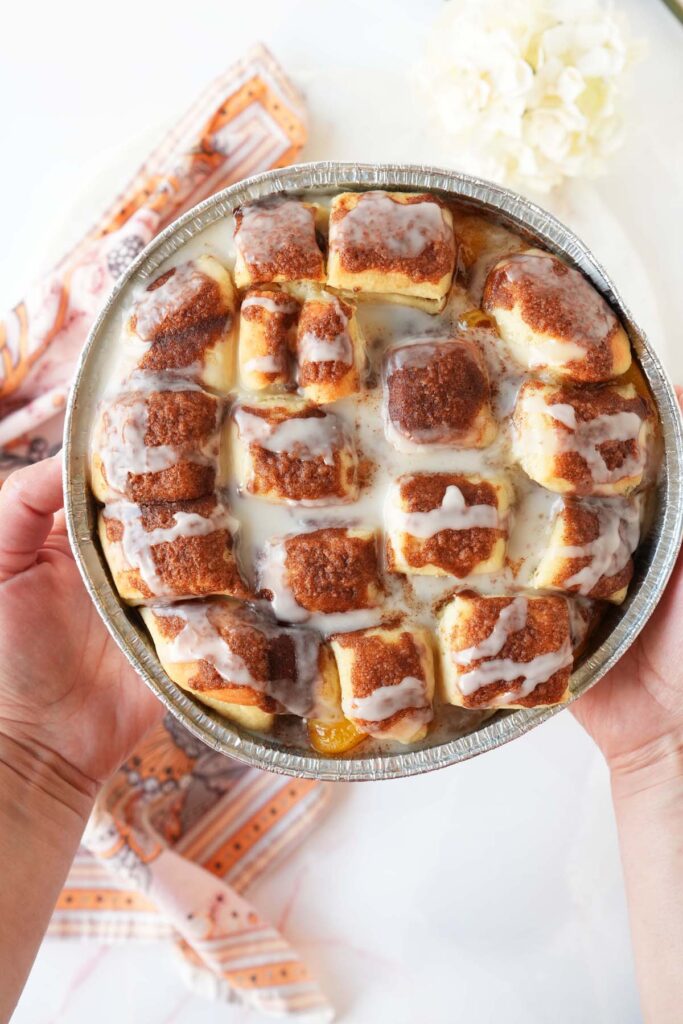 Hands holding peach cobbler buns.