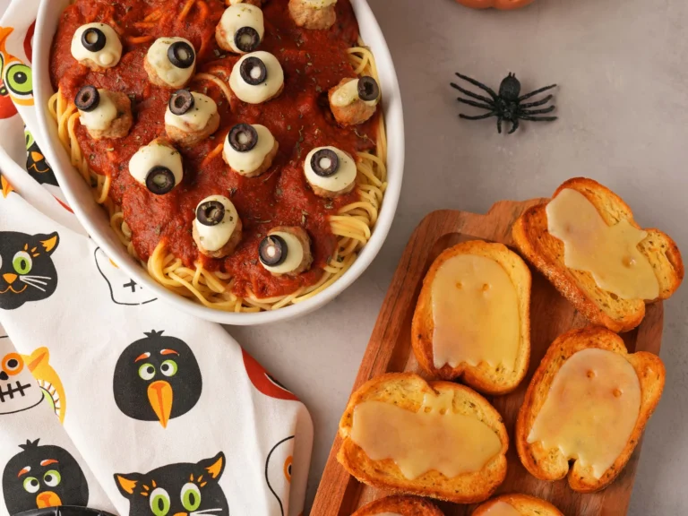 Halloween dinner with eyeball meatballs, spaghetti, and ghost-topped garlic toast.